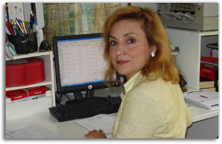 Mimi Afshar, M.Ed. at her desk, working at a computer with a data table on screen